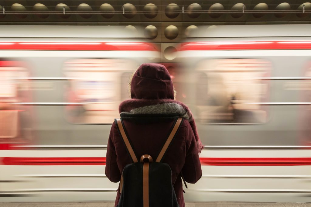 girl standing with the train passing by